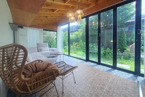 a screened in porch with a couch and chairs at Tasha's Garden Private Pension Jeonju Hanok Village in Jeonju