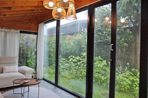 a living room with large windows and a couch and a table at Tasha's Garden Private Pension Jeonju Hanok Village in Jeonju