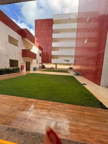 MacajatubaにあるAPTO de 3 quartos a 2km da praia do araçagyの草原の建物