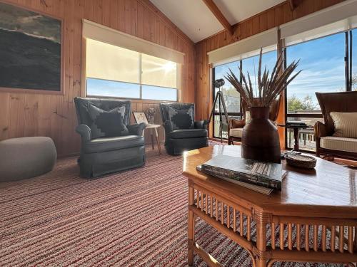 a living room with chairs and a table at High On Coffey - Binalong Bay - Pet Friendly in Binalong Bay
