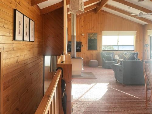a living room with wood paneled walls and a living room at High On Coffey - Binalong Bay - Pet Friendly in Binalong Bay