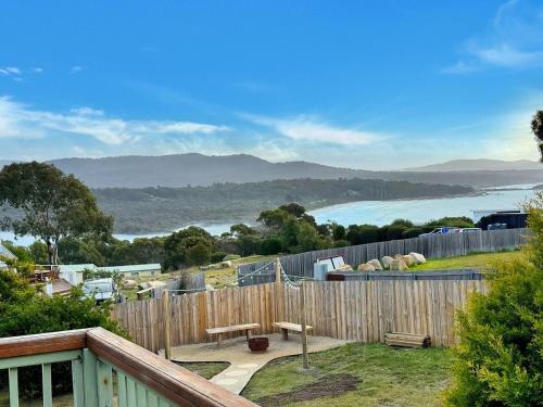a balcony with a wooden fence and a view of the water at High On Coffey - Binalong Bay - Pet Friendly in Binalong Bay