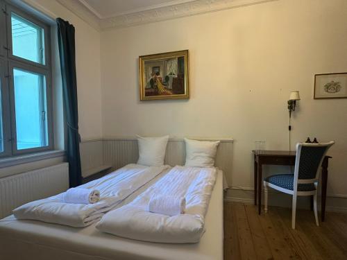 a bedroom with a bed and a desk and a window at Liselund Ny Slot Hotel in Borre