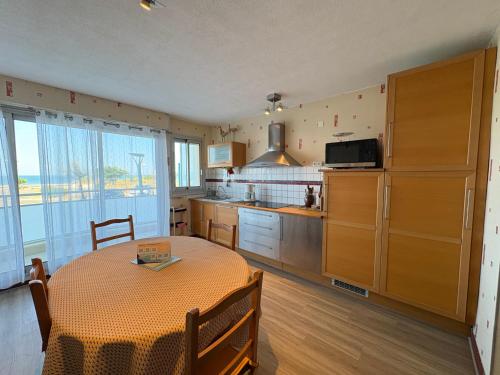 Il comprend une cuisine avec une table et une cuisine avec une table. dans l'établissement Bel appartement 2 chambres, pour 6 pers., face mer, à 50m de la plage - FR-1-323-297, à Saint-Jean-de-Monts