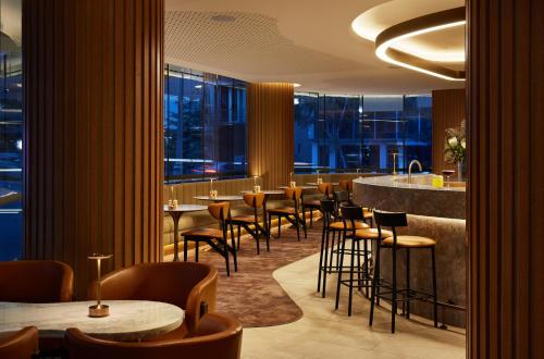 a restaurant with tables and chairs and a bar at Hyatt House South Melbourne in Melbourne