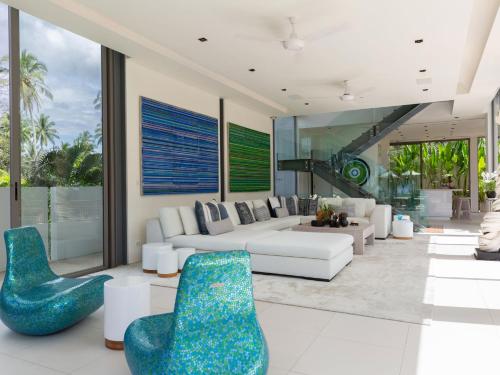 a living room with a white couch and blue chairs at Sava Ocean View Villas in Natai Beach