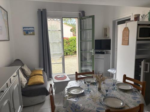 un salon avec une table et une salle à manger dans l'établissement Maison Confortable avec 2 Piscines, Proche Plage, Forêt et Pistes Cyclables à Saint-Jean-de-Monts - FR-1-323-484, à Saint-Jean-de-Monts