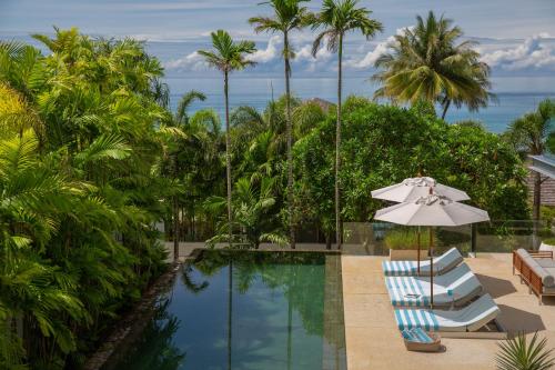 a swimming pool with two lounge chairs and an umbrella at Sava Ocean View Villas in Natai Beach