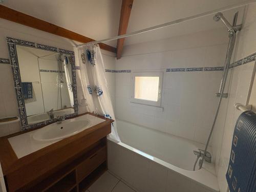 une salle de bain avec une baignoire, un lavabo et une douche dans l'établissement Maison avec piscine, proche forêt et plage à Saint Jean de Monts - FR-1-323-527, à Saint-Jean-de-Monts