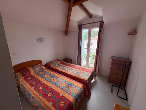 une chambre avec deux lits et une fenêtre dans l'établissement Maison avec piscine, proche forêt et plage à Saint Jean de Monts - FR-1-323-527, à Saint-Jean-de-Monts