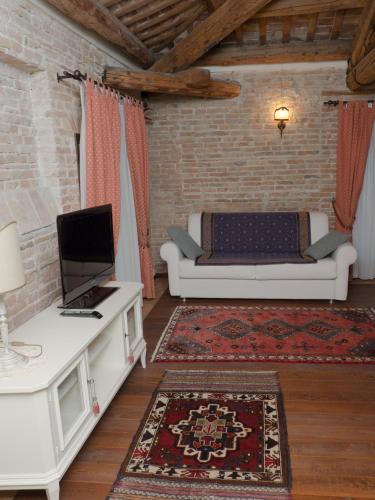 a living room with a couch and a tv at Agriturismo Villa Anconetta in Loreo
