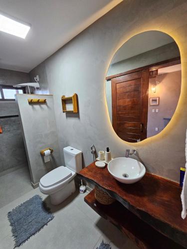 a bathroom with a toilet and a sink and a mirror at Chalé Duplex Beira Mar Macapá in Luis Correia