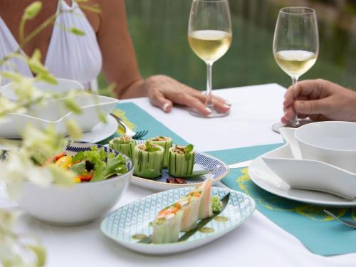 a table with plates of food and glasses of wine at Sava Ocean View Villas in Natai Beach