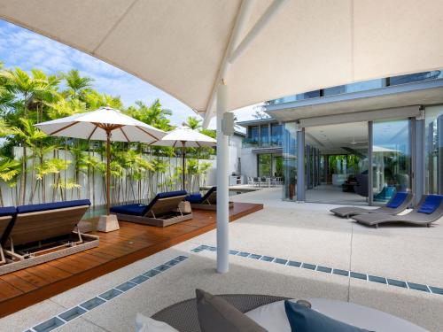 an outdoor patio with chairs and umbrellas at Sava Ocean View Villas in Natai Beach