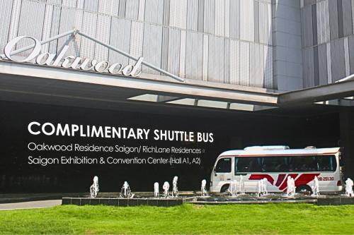 a bus is parked in front of a building at Oakwood Residence Saigon in Ho Chi Minh City