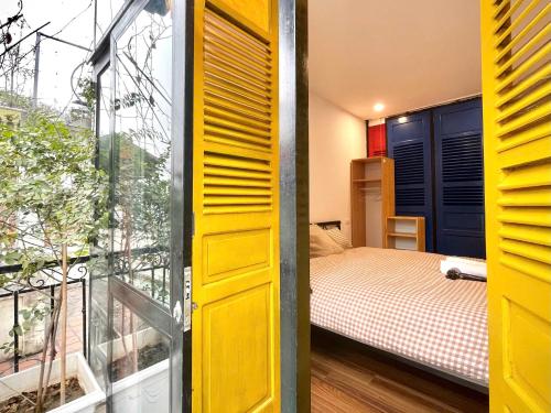 a small bedroom with a bed and a window at Ding Doong Homes in Hanoi