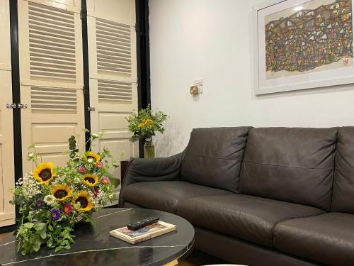 a living room with a couch and flowers on a table at Ding Doong Homes in Hanoi