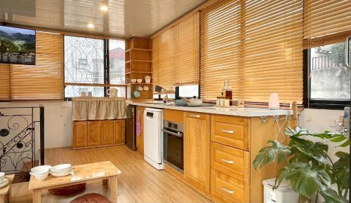a large kitchen with wooden cabinets and a table at Ding Doong Homes in Hanoi