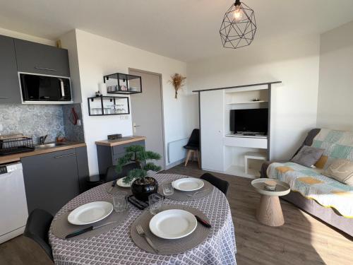 Il comprend un petit salon avec une table et une cuisine. dans l'établissement Appartement T2 avec balcon, piscine et parking à Saint-Jean-de-Monts - FR-1-323-568, à Saint-Jean-de-Monts