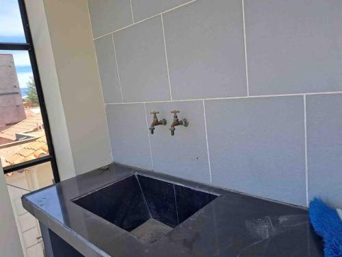 a bathroom with a sink and two faucets at Beautiful house downtown in Tarija