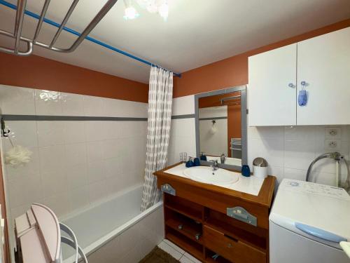 une salle de bain avec un lavabo et une baignoire dans l'établissement Maison charmante proche pistes cyclables, animaux admis - FR-1-323-567, à Saint-Jean-de-Monts