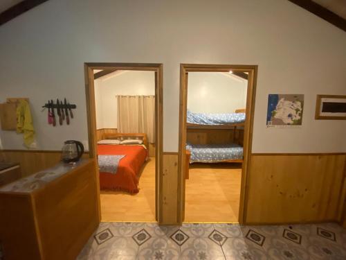 a room with a bedroom with a bed and a mirror at Cabañas La Paloma in Coñaripe