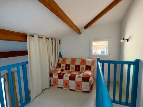 une pièce avec un berceau et une chaise dans une pièce dans l'établissement Maison charmante proche pistes cyclables, animaux admis - FR-1-323-567, à Saint-Jean-de-Monts