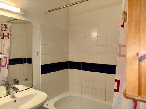 une salle de bain avec une baignoire, un lavabo et un miroir dans l'établissement Charmante maison de vacances à 400m de la plage - FR-1-323-565, à Saint-Hilaire-de-Riez