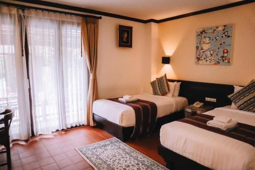 Postel nebo postele na pokoji v ubytování Baan Huenphen Boutique Hotel