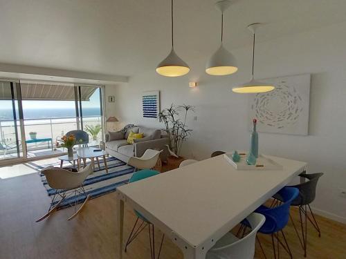 un salon avec une table et des chaises dans l'établissement Superbe appartement moderne face mer - Wifi gratuite - Proche commerces et plage - FR-1-323-257, à Saint-Jean-de-Monts