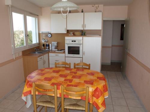 une cuisine avec une table et des chaises dans une cuisine dans l'établissement Appartement confortable 6 pers, face mer, animaux acceptés - FR-1-323-340, à Saint-Jean-de-Monts