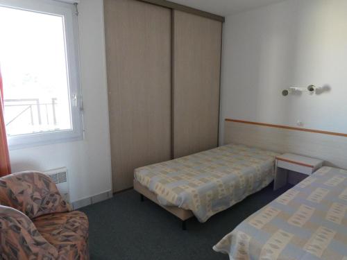 une chambre avec un lit, une chaise et une fenêtre dans l'établissement Appartement T2+ cabine avec piscine et parking à Saint-Jean-de-Monts - FR-1-323-315, à Saint-Jean-de-Monts