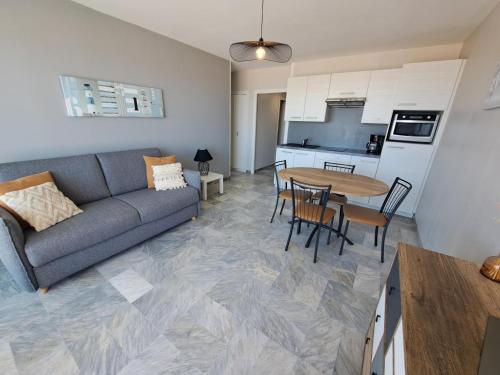 un salon avec un canapé et une table dans l'établissement Studio cabine avec balcon près des commerces - FR-1-323-424, à Saint-Jean-de-Monts