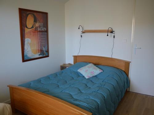 une chambre avec un lit avec une couette bleue dans l'établissement Appartement Spacieux - 3 Chambres - Proche Plage et Golf avec Piscine - FR-1-323-487, à Saint-Jean-de-Monts