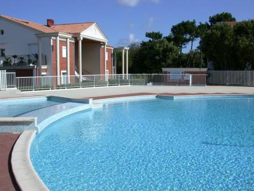 une grande piscine bleue devant une maison dans l'établissement Appartement Spacieux - 3 Chambres - Proche Plage et Golf avec Piscine - FR-1-323-487, à Saint-Jean-de-Monts