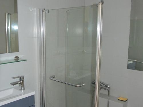 une douche avec une porte vitrée dans une salle de bain dans l'établissement Appartement Spacieux - 3 Chambres - Proche Plage et Golf avec Piscine - FR-1-323-487, à Saint-Jean-de-Monts