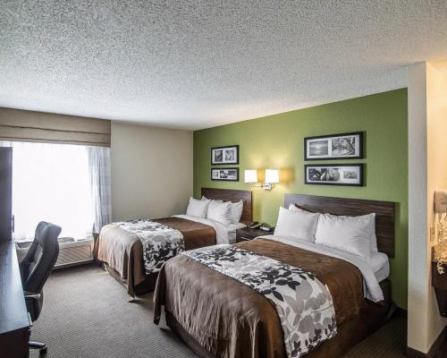 a hotel room with two beds and a window at Sleep Inn South Joplin in Joplin