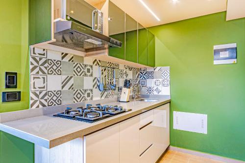 a kitchen with green and white walls and a stove at Edificio Habitare Cristales Cali 2 in Cali