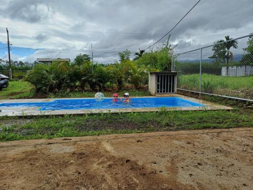 two people in a swimming pool in a yard at Casa a 10 min de la Fortuna in Fortuna