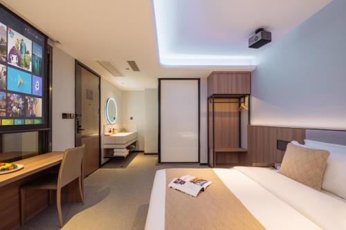 a room with a bed and a table and a television at Xi'an Bell and Drum Tower Yongning Gate Lanfeng Hotel in Xi'an
