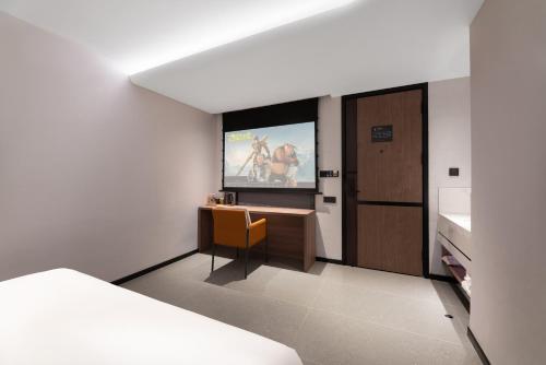 a room with a tv and a room with a bed at Xi'an Bell and Drum Tower Yongning Gate Lanfeng Hotel in Xi'an