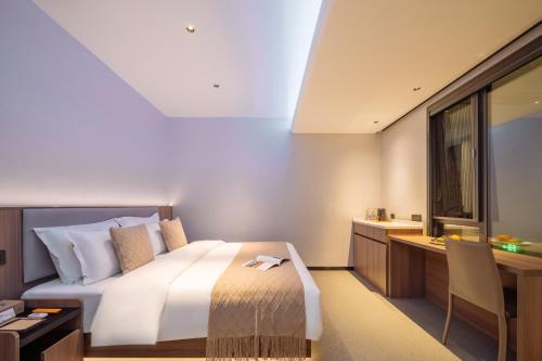 a hotel room with a bed and a desk and a window at Xi'an Bell and Drum Tower Yongning Gate Lanfeng Hotel in Xi'an