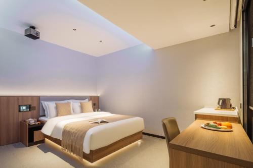 a bedroom with a bed and a table and a desk at Xi'an Bell and Drum Tower Yongning Gate Lanfeng Hotel in Xi'an