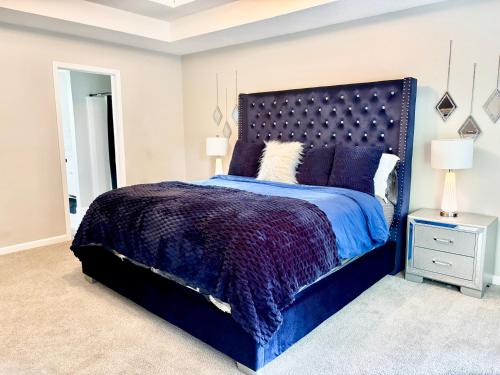 a bedroom with a blue bed with a purple comforter at King Suite - Game Room - Gym - Private Bath - Hot Tub in Ellenwood