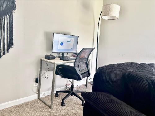 a desk with a computer monitor and a chair at King Suite - Game Room - Gym - Private Bath - Hot Tub in Ellenwood