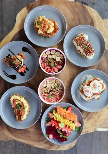 een groep borden met voedsel op een houten tafel bij Aqua Dive resort Amed in Amed