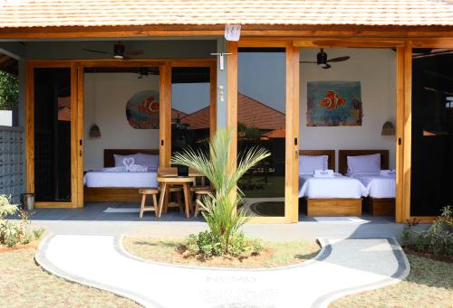 een gastenverblijf met twee bedden en een patio bij Aqua Dive resort Amed in Amed