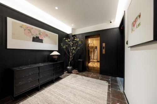 a hallway with black walls and a black dresser at Beijing Tangfu Nanluoguxiang Tian an Men Lama Temple San Li Tun Snack Street Hotel,Free Laundry Dry Service and Free Afternoon Tea &professional Free Tour Ticket Service with English Speaking Staff in Beijing