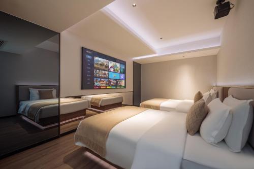 a hotel room with two beds and a flat screen tv at Xi'an Bell and Drum Tower Yongning Gate Lanfeng Hotel in Xi'an