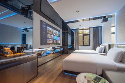 a bedroom with a bed and a living room at Xi'an Bell and Drum Tower Yongning Gate Lanfeng Hotel in Xi'an